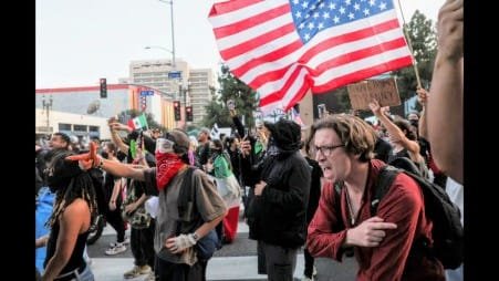 Demonstran bereaksi terhadap amunisi pengendali massa yang ditembakkan ke arah mereka saat protes terhadap penyisiran imigrasi federal terus berlanjut, di pusat kota Los Angeles, California, AS, 10 Juni 2025. REUTERS/Leah Millis.