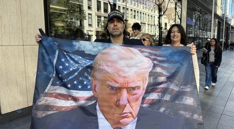 Seorang pendukung dengan spanduk Donald Trump pada tahun 2024. (Foto CNA)