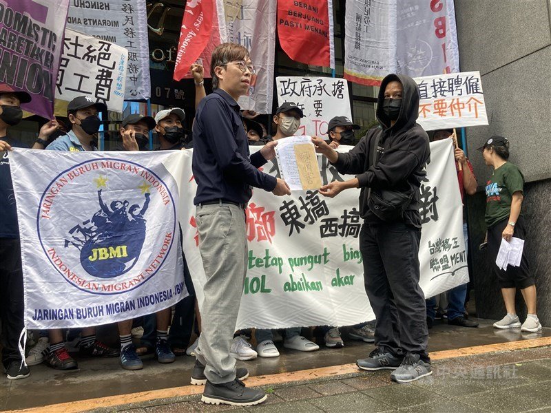 Pihak demonstran dari massa PMA (kanan) memberikan tuntutan pada perwakilan MoL (kiri) dalam aksi demonstrasi menolak pungutan liar di depan MoL, 19 Oktober 2025. (Sumber Foto : CNA, 19 Oktober 2025)