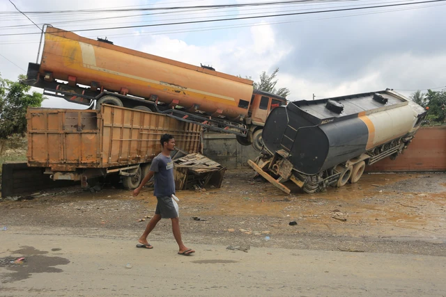 Seorang warga melintas di dekat truk tangki yang terbawa arus banjir di Desa Bukit Rata, Kejuruan muda, Kabupaten Aceh Tamiang, Aceh, Rabu (3/12/2025). Foto: Syifa Yulinnas/ANTARA FOTO