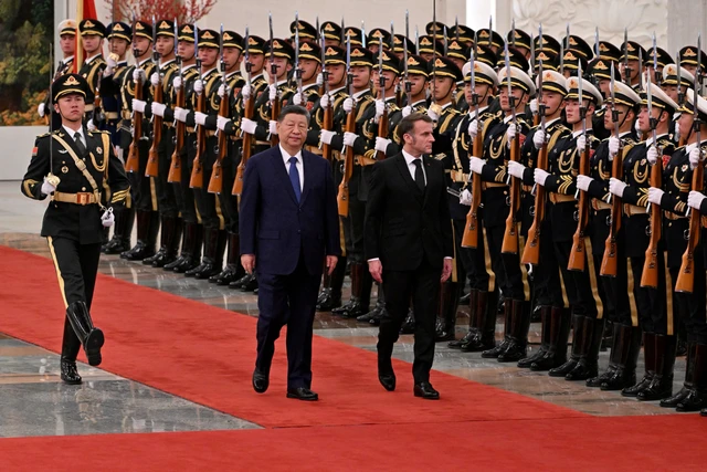 Presiden China Xi Jinping menyambut kedatangan Presiden Prancis Emmanuel Macron sebelum pertemuan di Beijing, China, Kamis (4/12/2025). Foto: Adek Berry/Pool via REUTERS