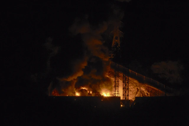 Kebakaran setelah ledakan dan pesawat terbang rendah saat serangan udara yang diduga dari Amerika Serikat di kompleks militer terbesar Fuerte Tiuna, Caracas, Venezuela, Sabtu (3/1/2026). Foto: Luis James/AFP