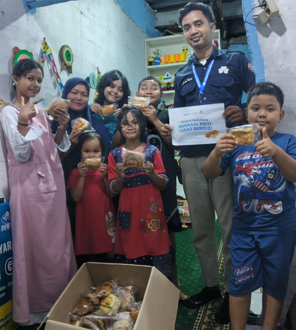 Aldy selaku Relawan dari Sahabat Yatim untuk menyalurkan "Berbagi Roti Lezat Bergizi" kepada adik adik di TBM Baung. FOTO: Henny06-PBMI