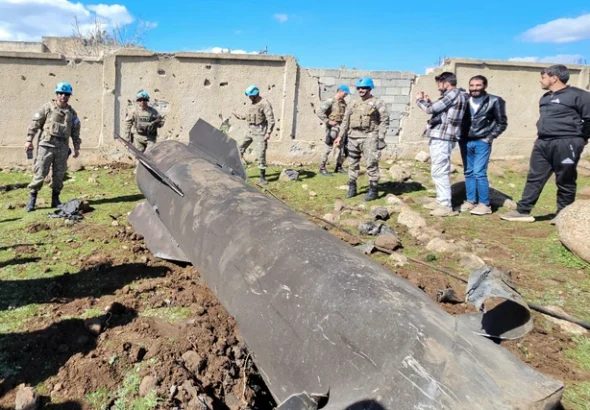 Penjaga perdamaian PBB dan warga berdiri di dekat puing rudal Iran yang dilaporkan dicegat pasukan Israel di pedesaan selatan Quneitra dekat Dataran Tinggi Golan, Sabtu (28/2). Foto: Bakr Alkasem/AFP