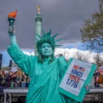 Seorang wanita yang berpakaian seperti Patung Liberty ikut serta dalam protes "Tidak Ada Raja" di Paris, Prancis, Sabtu, 28 Maret 2026. Foto: AP Photo/Aurelien Morissard