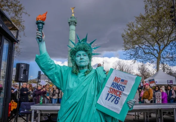 Seorang wanita yang berpakaian seperti Patung Liberty ikut serta dalam protes "Tidak Ada Raja" di Paris, Prancis, Sabtu, 28 Maret 2026. Foto: AP Photo/Aurelien Morissard