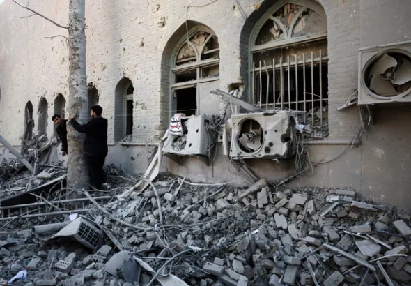 Orang-orang berdiri di tengah reruntuhan bangunan Universitas Teknologi Sharif, yang rusak akibat serangan, di tengah konflik AS-Israel dengan Iran, di Teheran, Iran, Selasa (7/4/2026). Foto: Majid Asgaripour/WANA via REUTERS