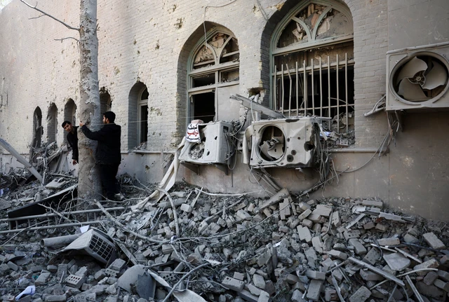 Orang-orang berdiri di tengah reruntuhan bangunan Universitas Teknologi Sharif, yang rusak akibat serangan, di tengah konflik AS-Israel dengan Iran, di Teheran, Iran, Selasa (7/4/2026). Foto: Majid Asgaripour/WANA via REUTERS