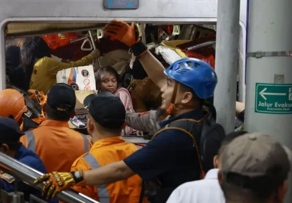 Petugas mengevakuasi korban yang masih terjebak di dalam gerbong KRL Commuterline yang bertabrakan dengan KA Argo Bromo Anggrek di Stasiun Bekasi Timur, Bekasi, Jawa Barat, Senin (27/04). FOTO: ANTARA