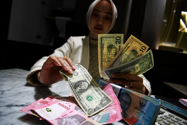 Petugas menunjukkan pecahan mata uang dolar Amerika Serikat dan mata uang Rupiah di Kantor Cabang BNI Pasar Baru, Jakarta, Selasa (10/3/2026). Foto: Muhammad Adimaja/ANTARA FOTO