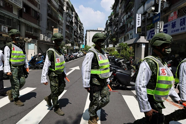 Petugas polisi militer bersiap untuk latihan tentang cara membimbing warga ke tempat yang aman jika terjadi serangan, di Taipei, Taiwan. Foto: Ann Wang/REUTERS