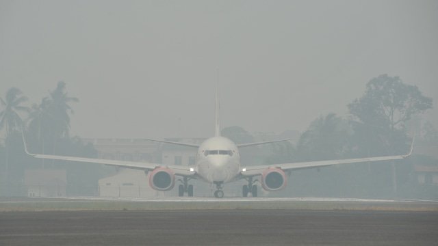 Sebuah pesawat udara bersiap lepas landas di Bandara Sultan Thaha yang diselimuti kabut asap karhutla, Jambi, Senin (23/9/2019). Foto: ANTARA FOTO/Wahdi Septiawan